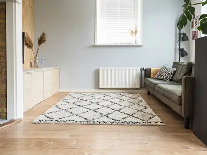 Empty bright room with light wood floor, a white wall and a single window